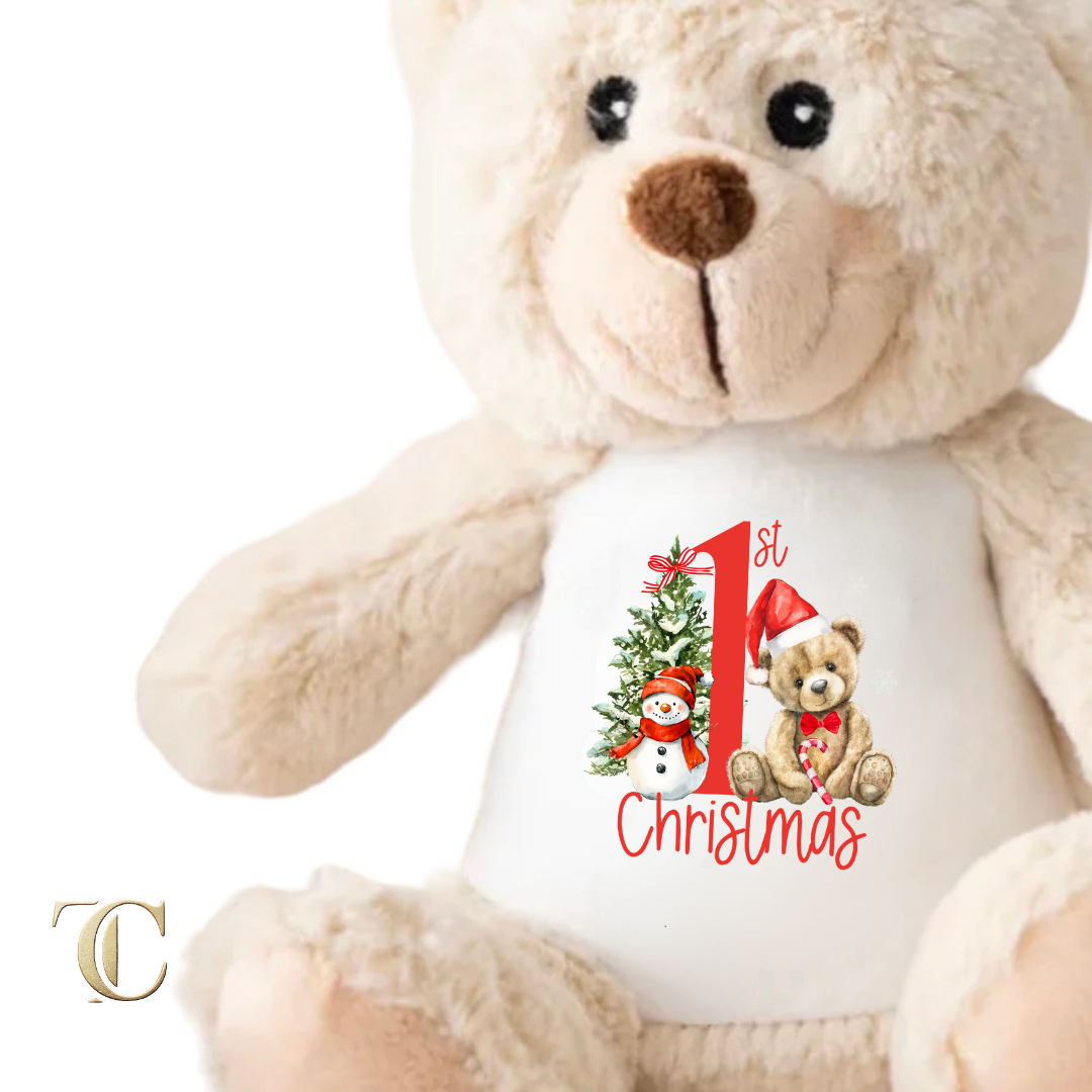 Beige teddy bear wearing a white shirt with a Christmas design and text.