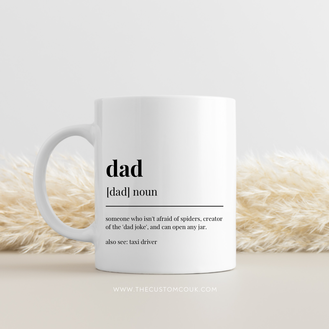 White mug with a definition of 'dad' on a light background
