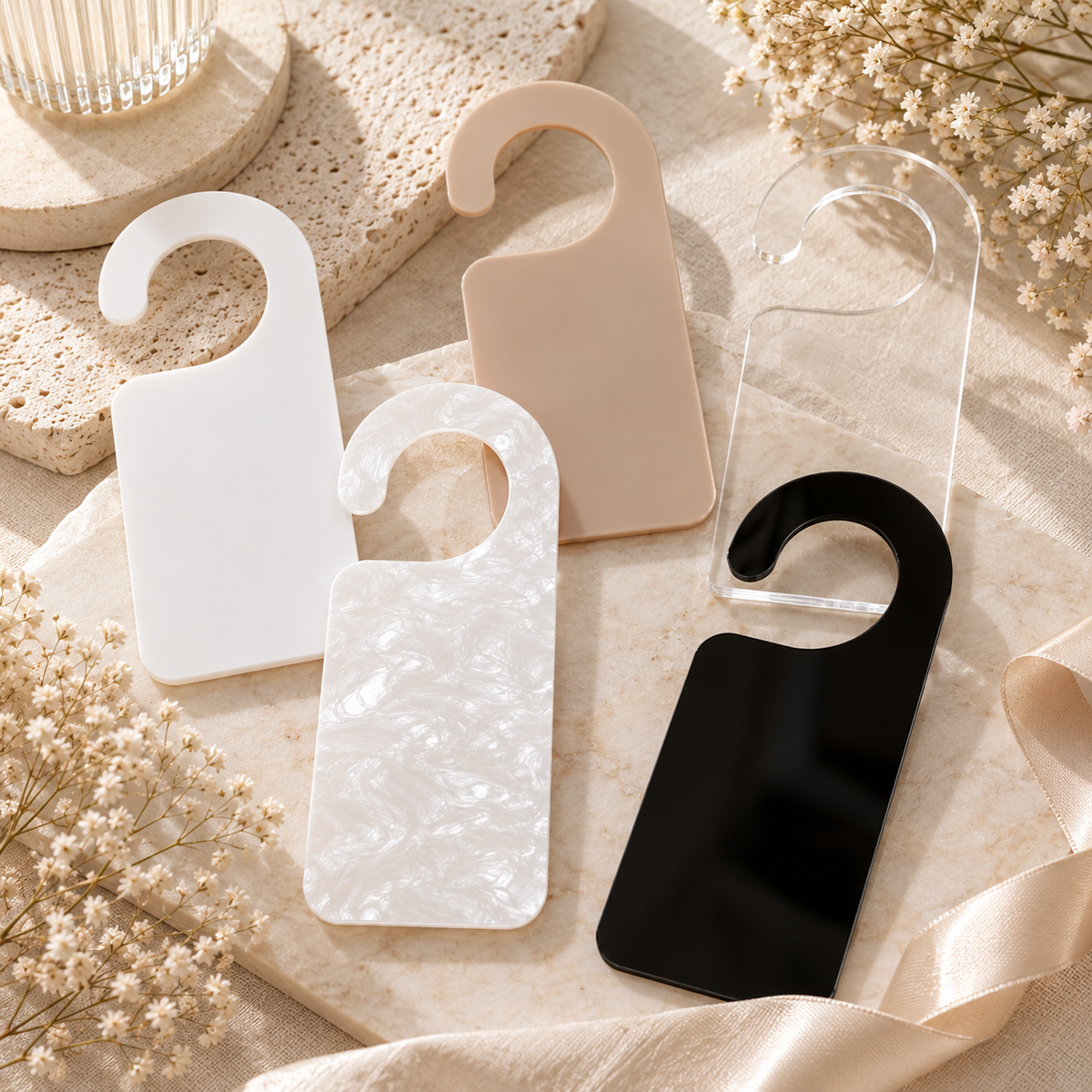 Custom acrylic business door hangers in white, pearlescent, nude, clear and black finishes, designed for personalised business branding and signage.
