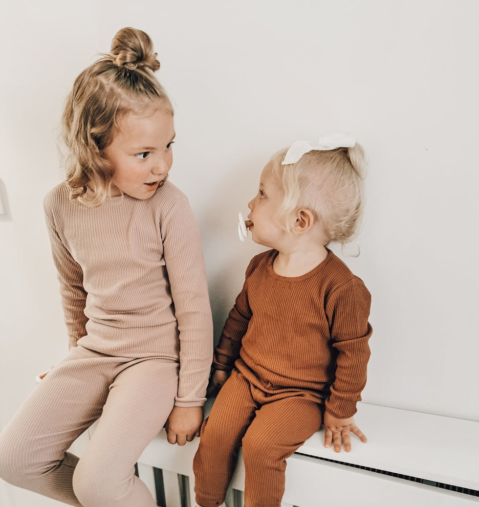 Matching ribbed pajamas sitting on a white surface.