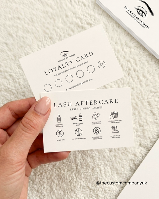 Hand holding a loyalty card for lash aftercare on a textured surface