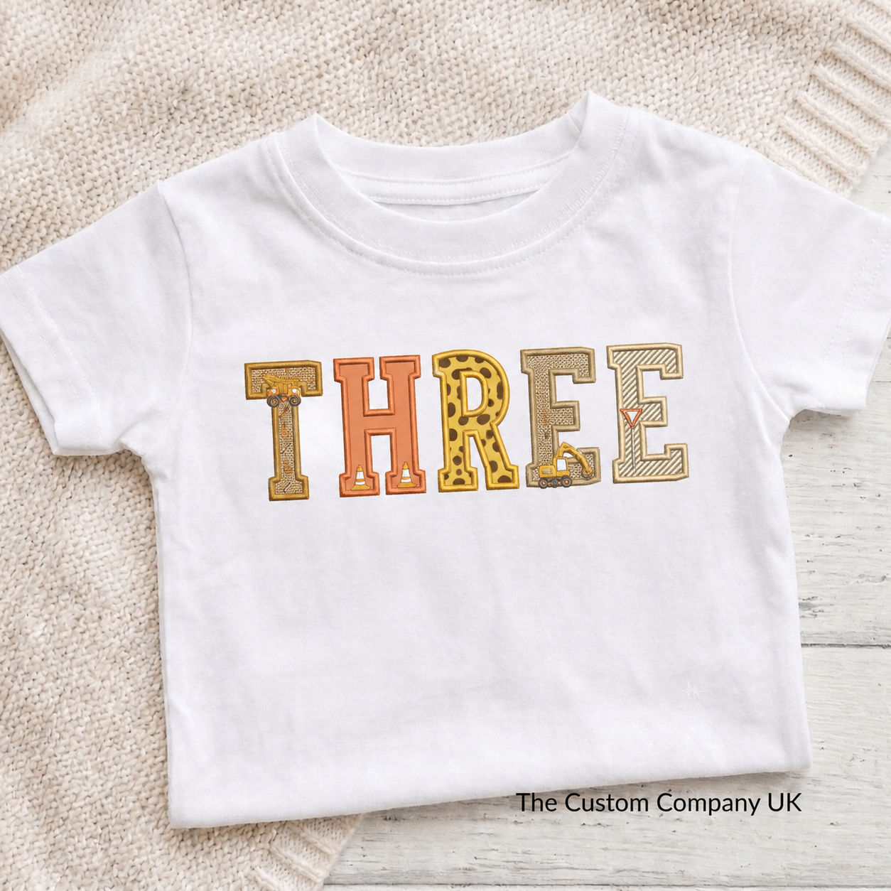 Custom construction birthday t-shirt with 'THREE' printed in embroidered letters.
