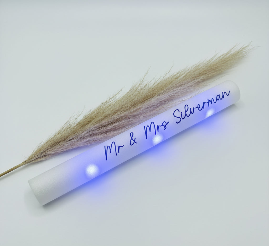 White tube with 'Mr & Mrs Silverman' text and dried pampas grass on a white background