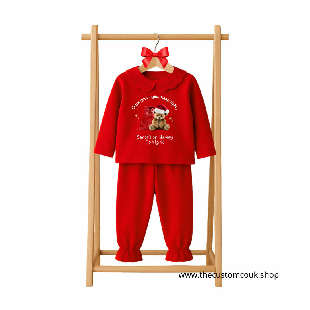 Personalised red frilly girls’ Christmas pyjamas with bear design, frill sleeves, and festive text “Close your eyes, sleep tight, Santa’s on his way.”